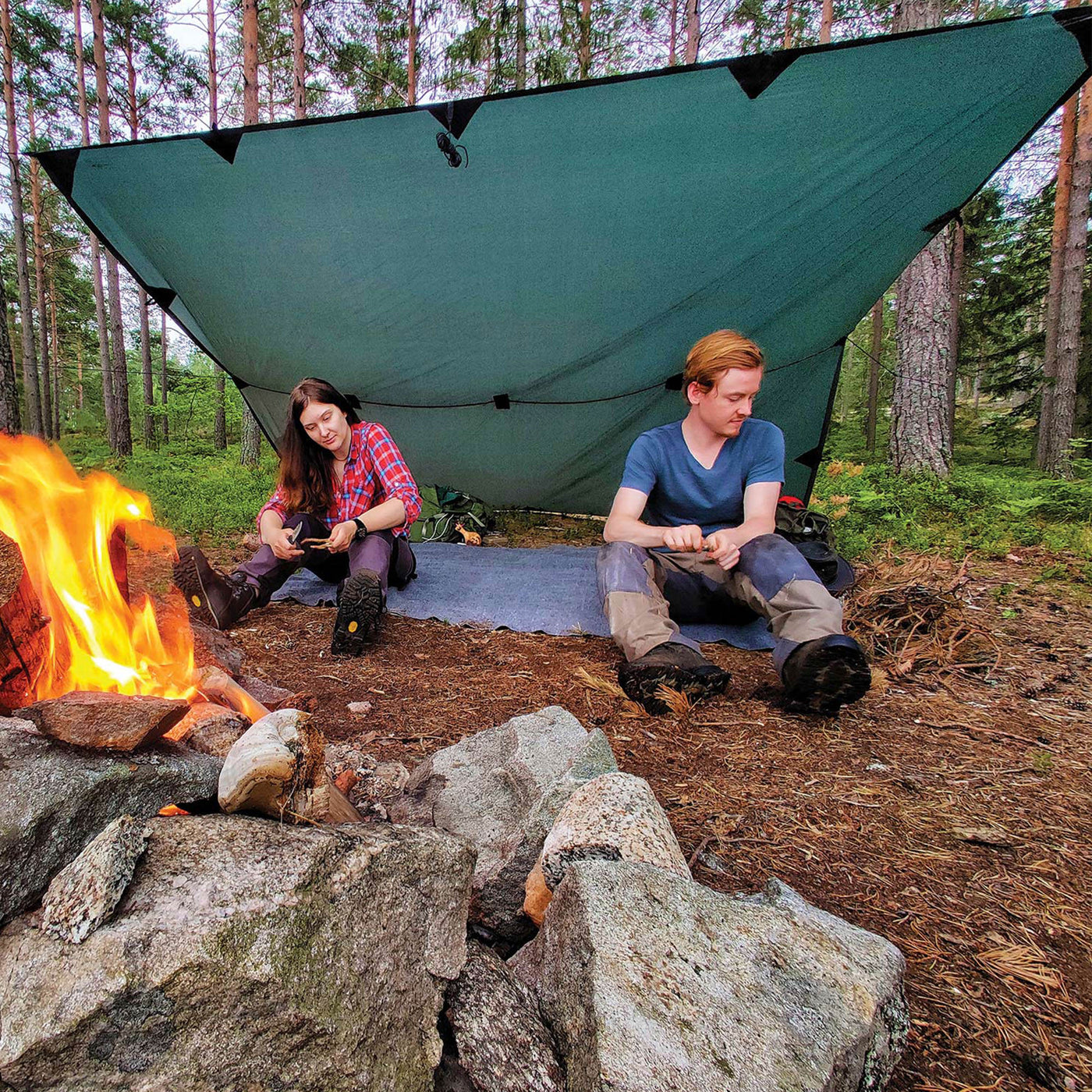 coppia fa bushcraft nel bosco con un DD TARP e il fuoco
