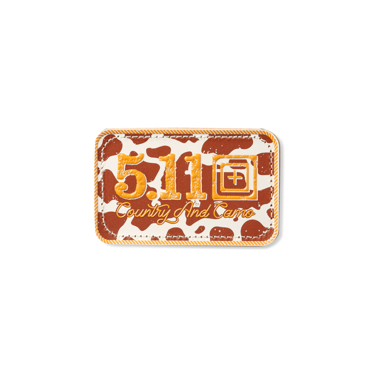 Patch ricamata in pelle 5.11 Tactical Country And Camo, sfondo con fantasia a macchie di mucca (cow print) marrone e beige, scritta 5.11 e testo Country And Camo in arancione, patch rettangolare con bordo cucito a cordoncino