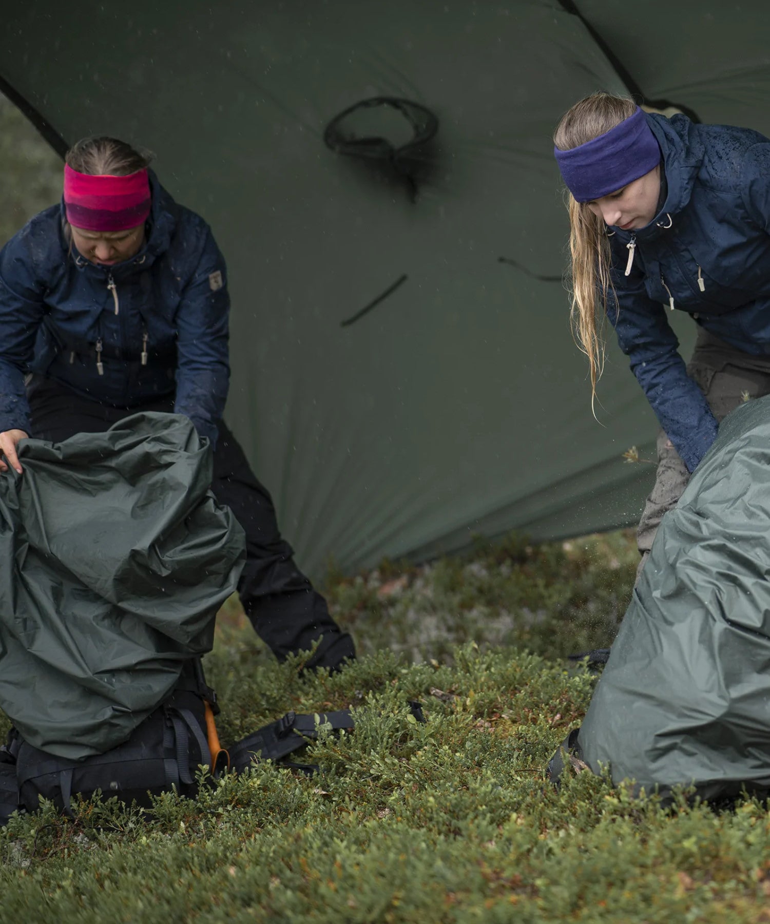 donna cerca nel suo zaino scostando la cover antipioggia savotta