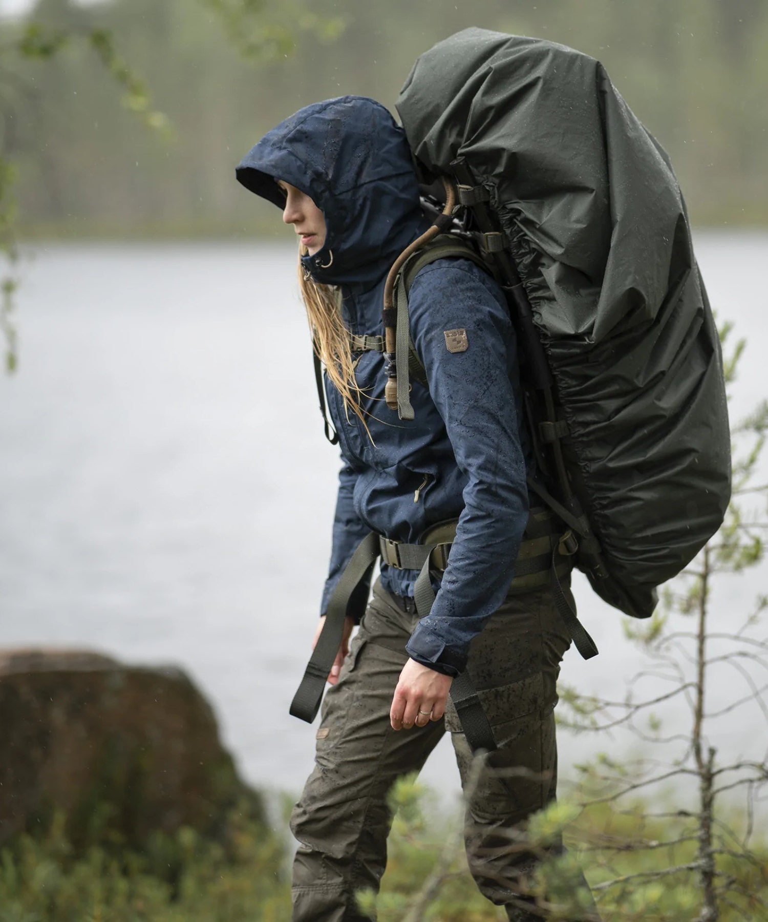 donna in escursione con il suo jaakari XL e la cover antipioggia