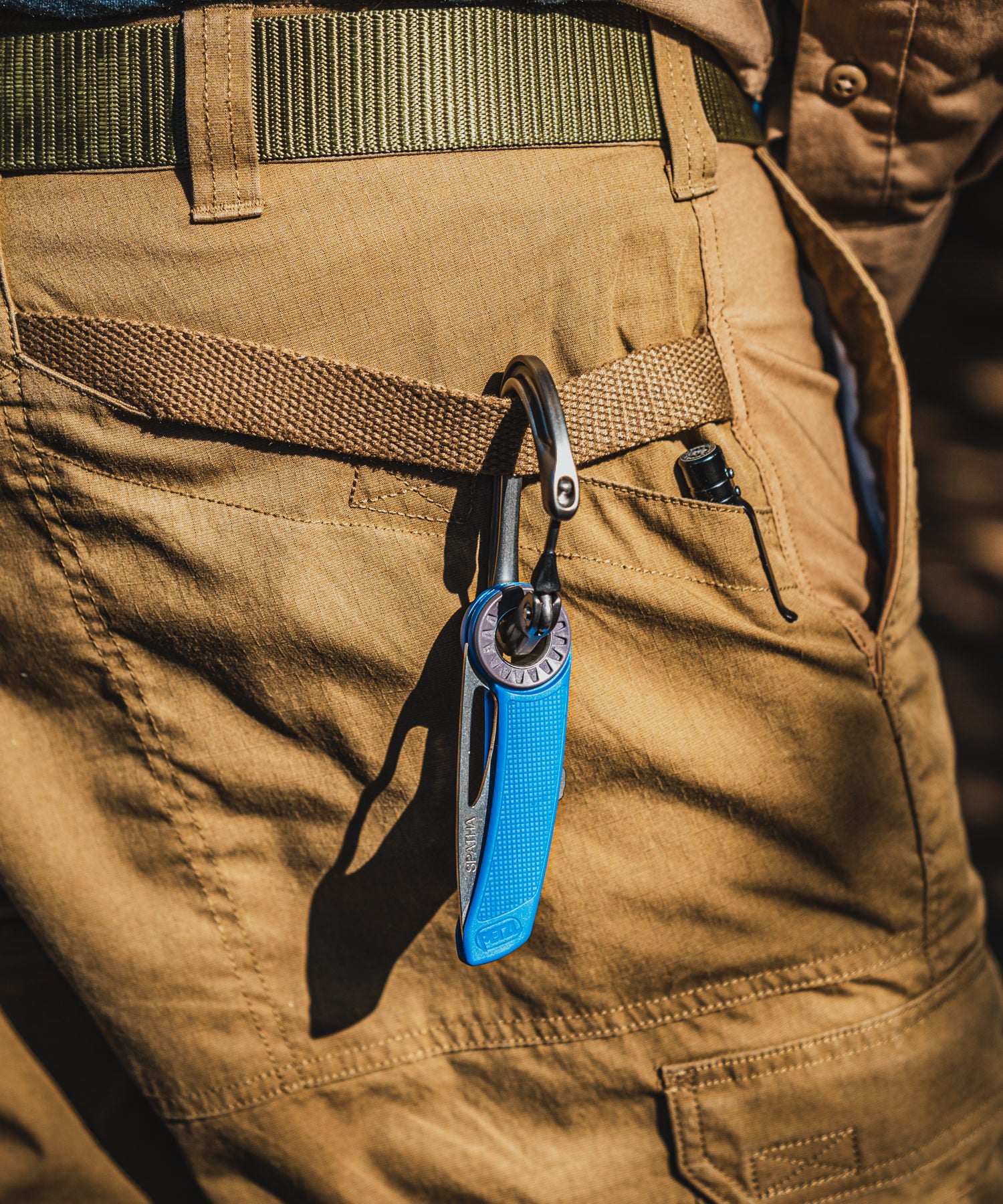 paolo di backpacco porta un moschettone da arrampicata ai pantaloni 5.11 con il petzl spatha blu