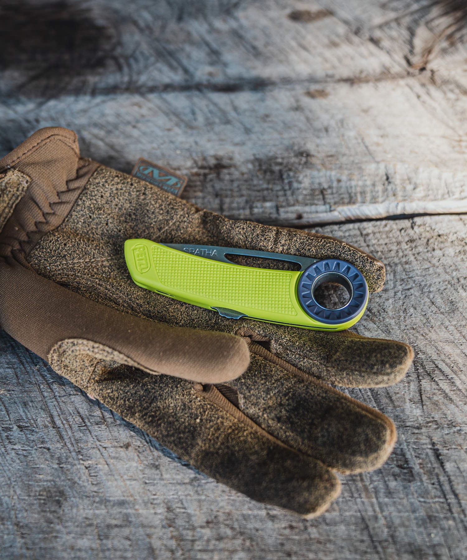 coltello petzl giallo chiuso con guanto da lavoro mechanix