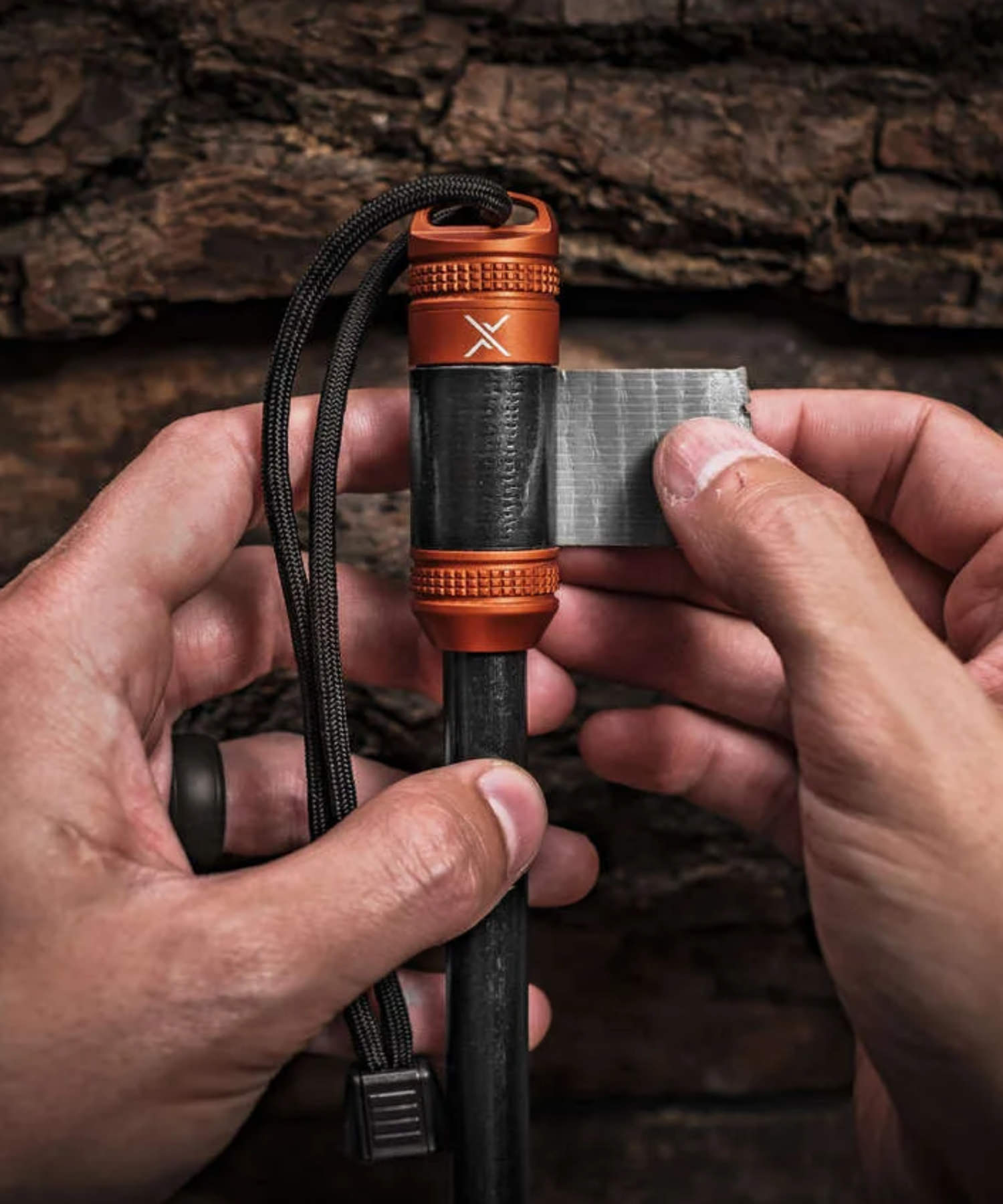 Firerod xl di exotac arancione su tavolo con kit fuoco con nastro americano per riparazioni ed esche