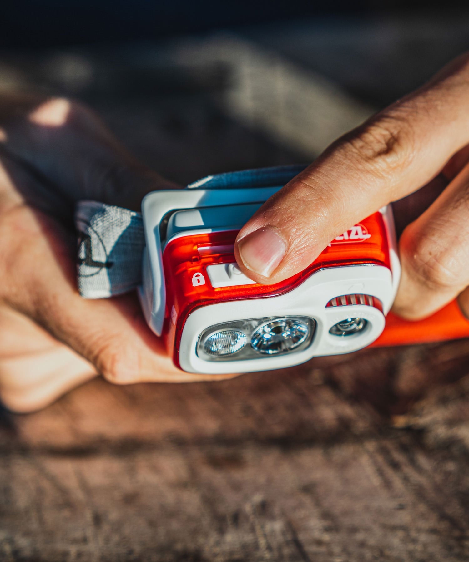 Paolo di backpacco mostra la torcia frontale petzl swift rl rossa - dettaglio del pulsante