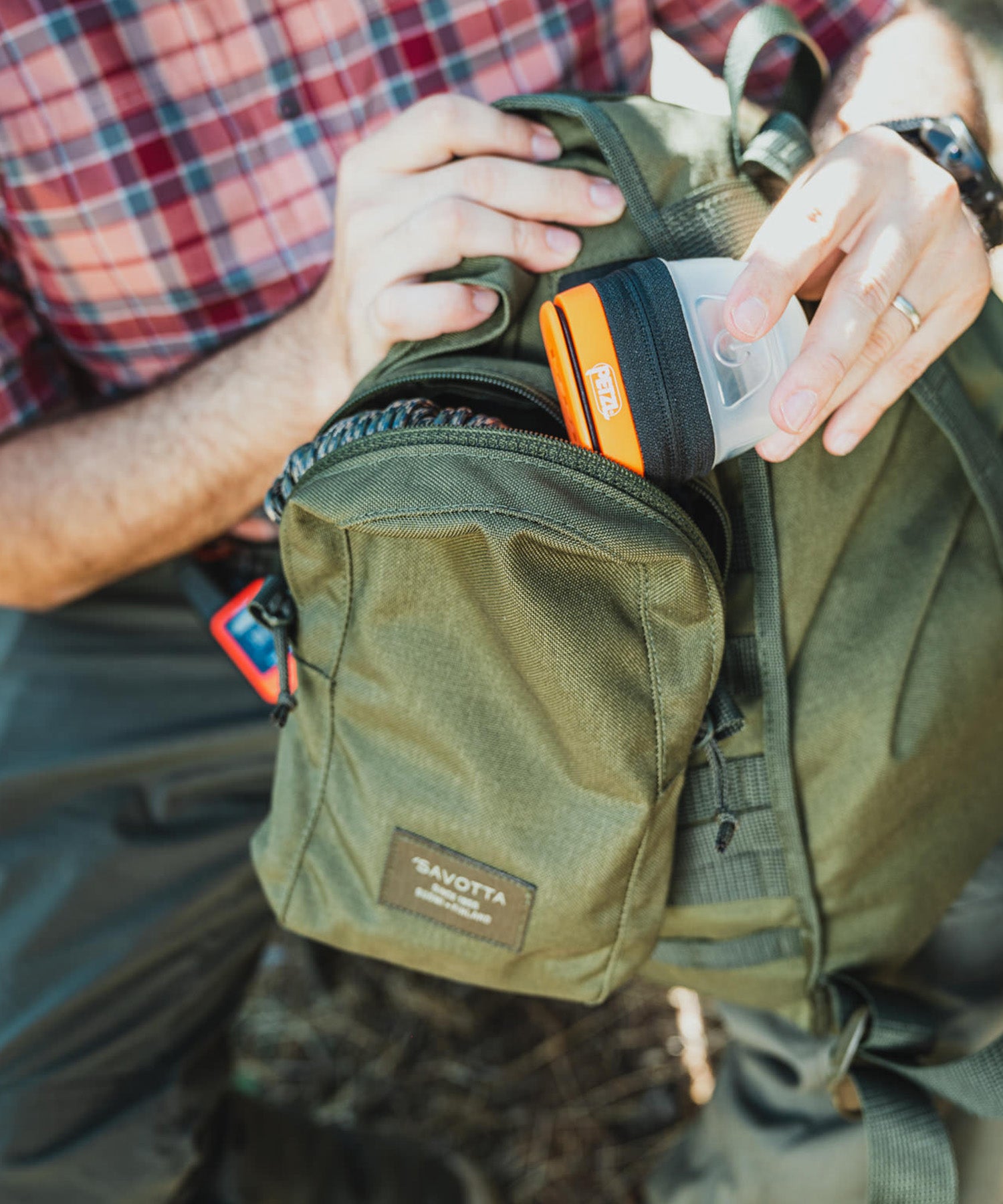 Paolo di backpacco sistema la torcia petzl nella tasca verticale dello zaino savotta