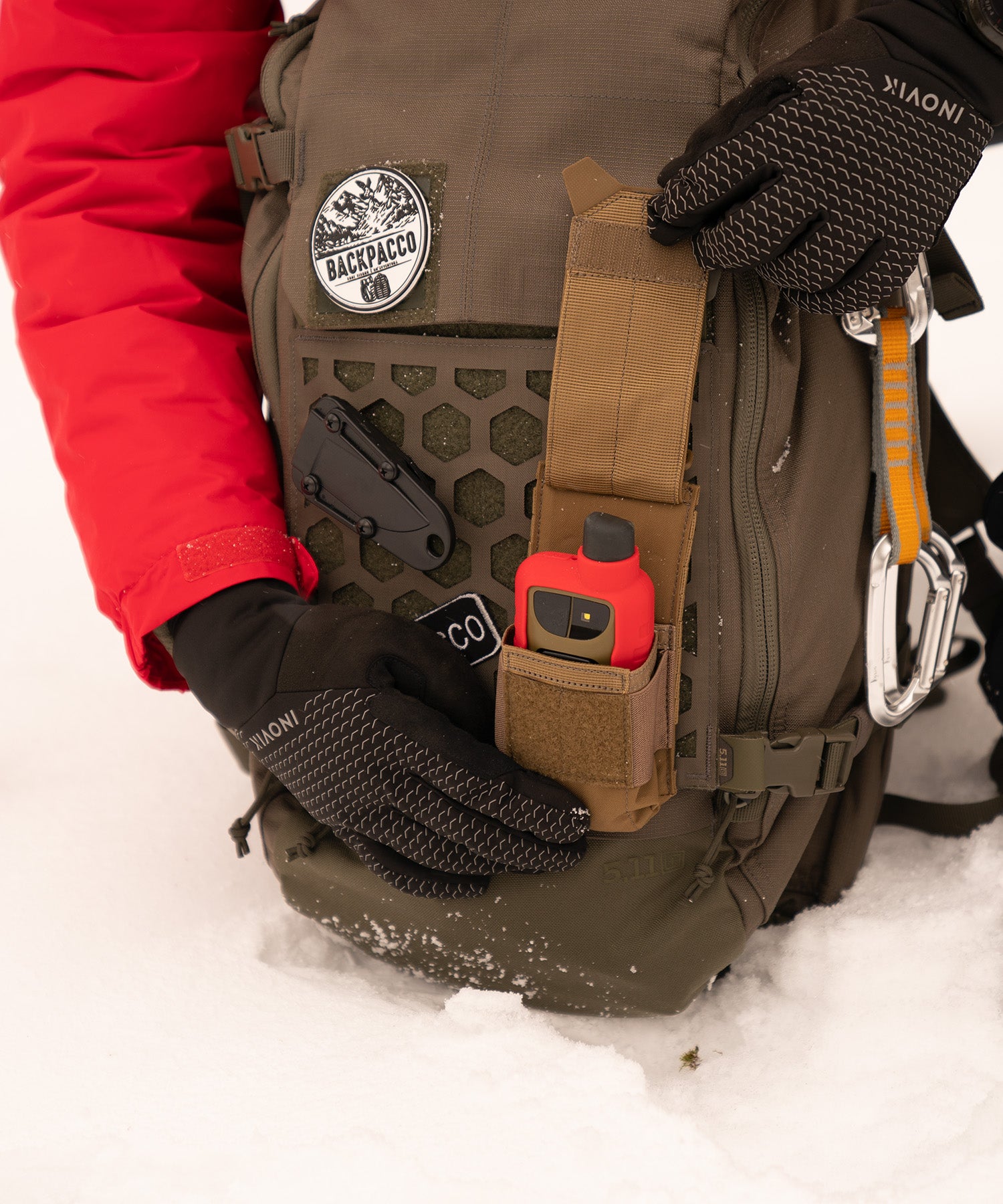 Paolo di backpacco mostra la tasca flash bang pouch di 5.11 con il gps Garmin GPSMAP durante un'escursione sulla neve