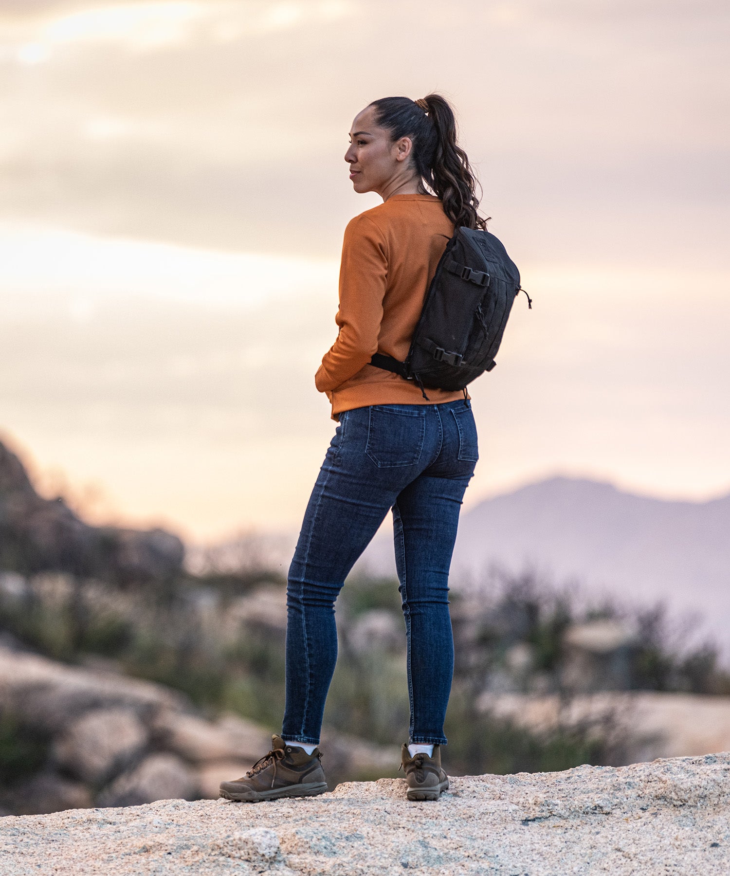Ragazza fa una pausa durante un'escursione con 5.11 tactical sling pack nero
