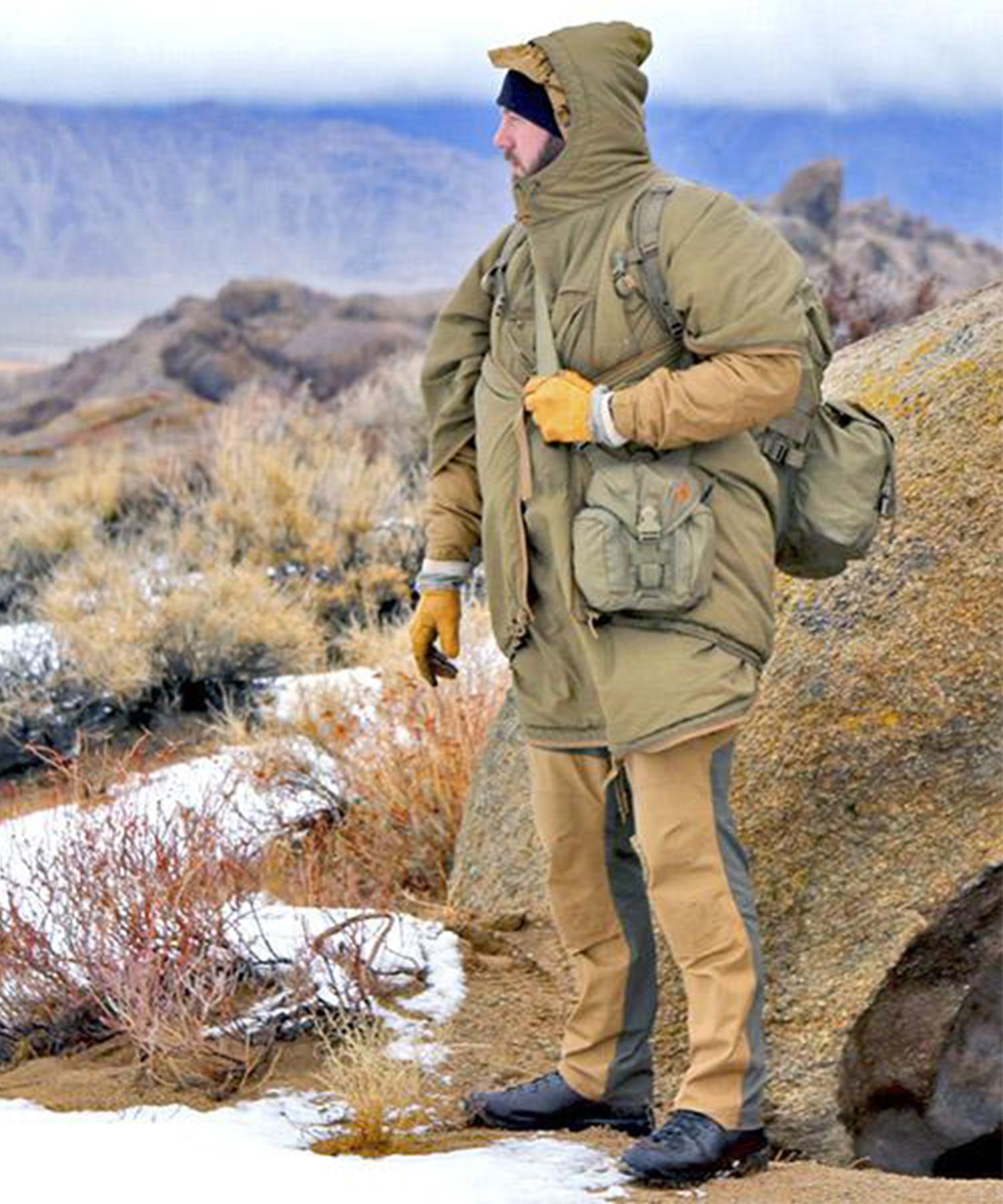 Uomo indossa swagman roll durante un'escursione nella neve