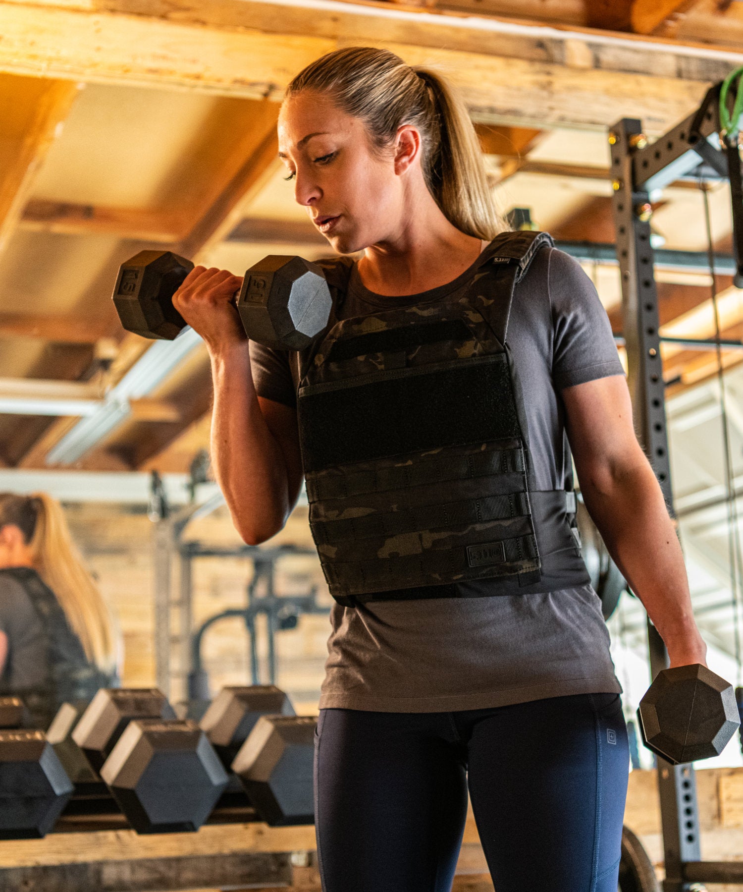 donna si allena con il curl e il 5.11 tactec trnr weight vest