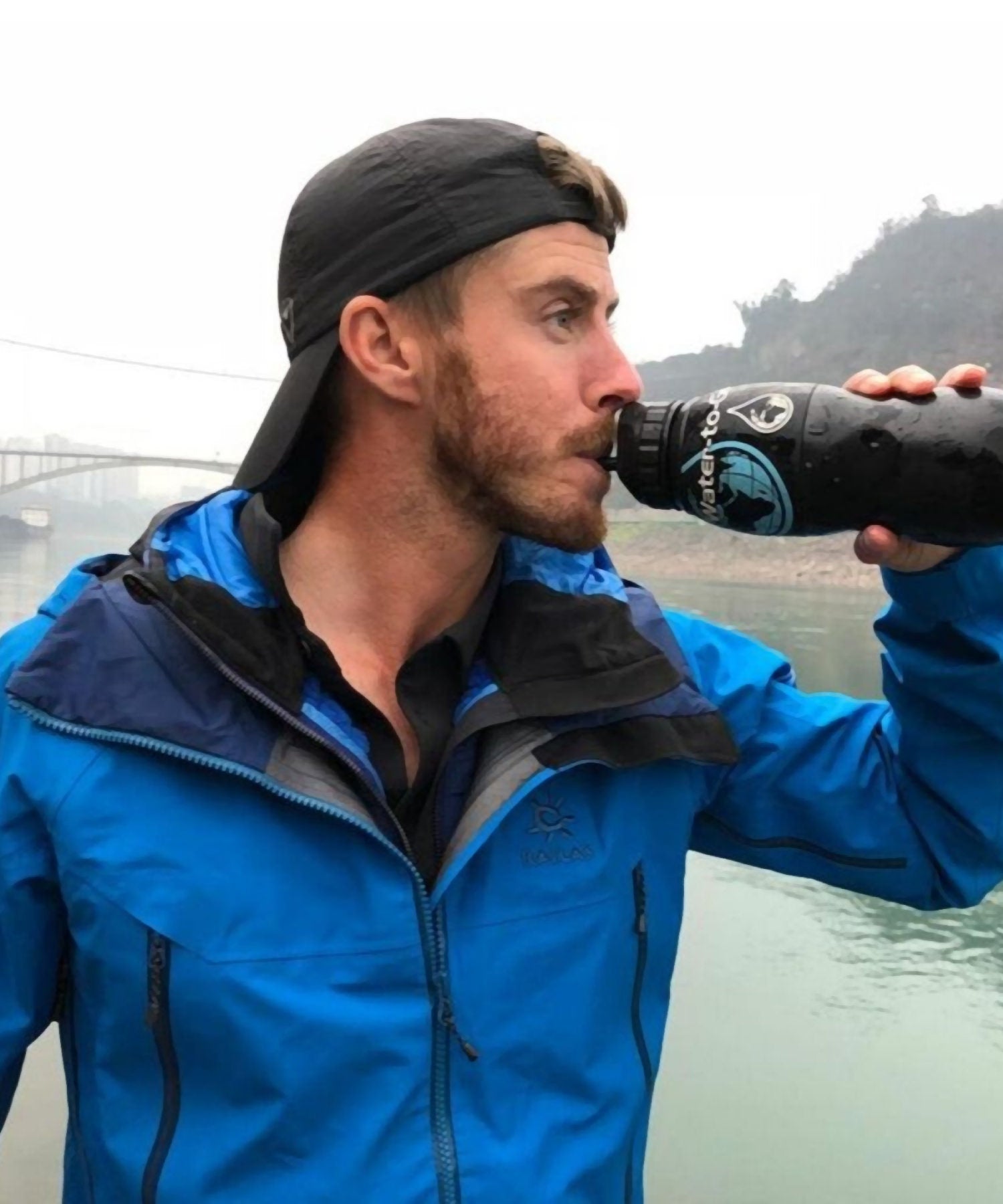 uomo beve dalla borraccia water-to-go classic in laguna