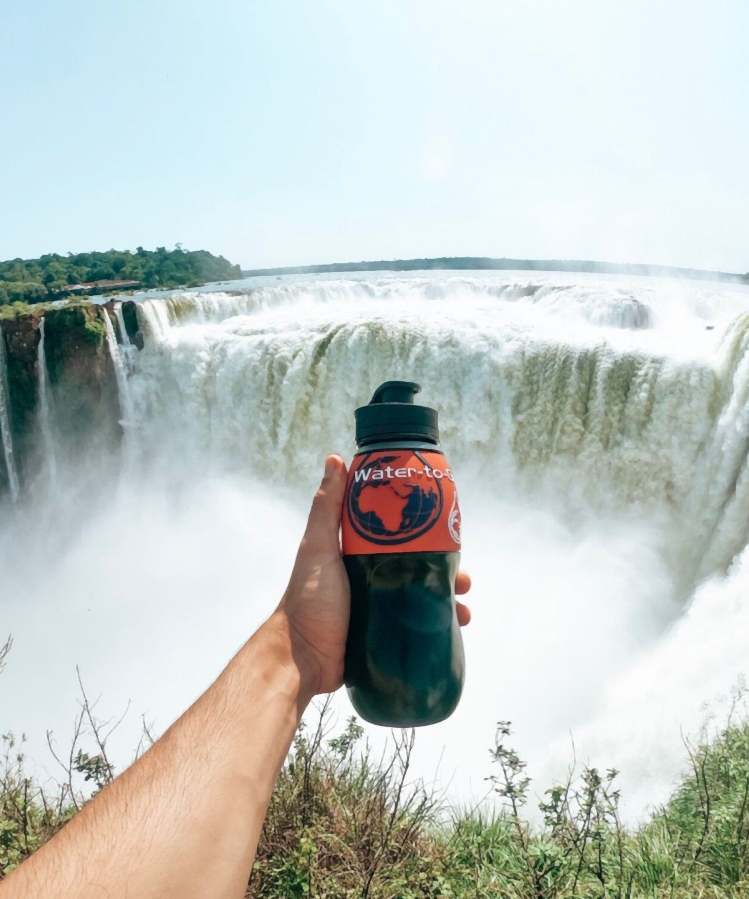 borraccia water-to-go mostrata davanti una cascata