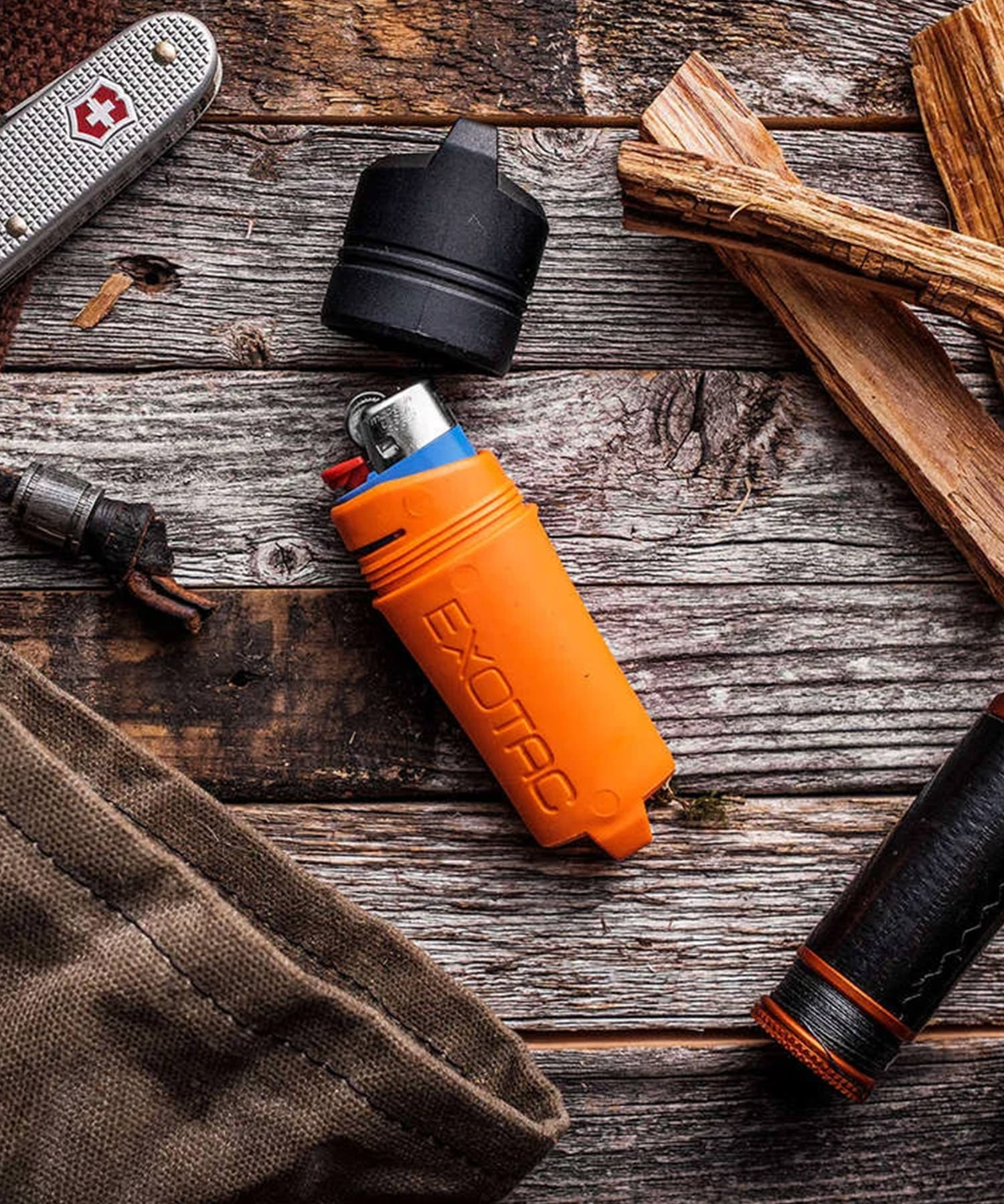 exotac firesleeve arancione posato su tavolo con attrezzi bushcraft