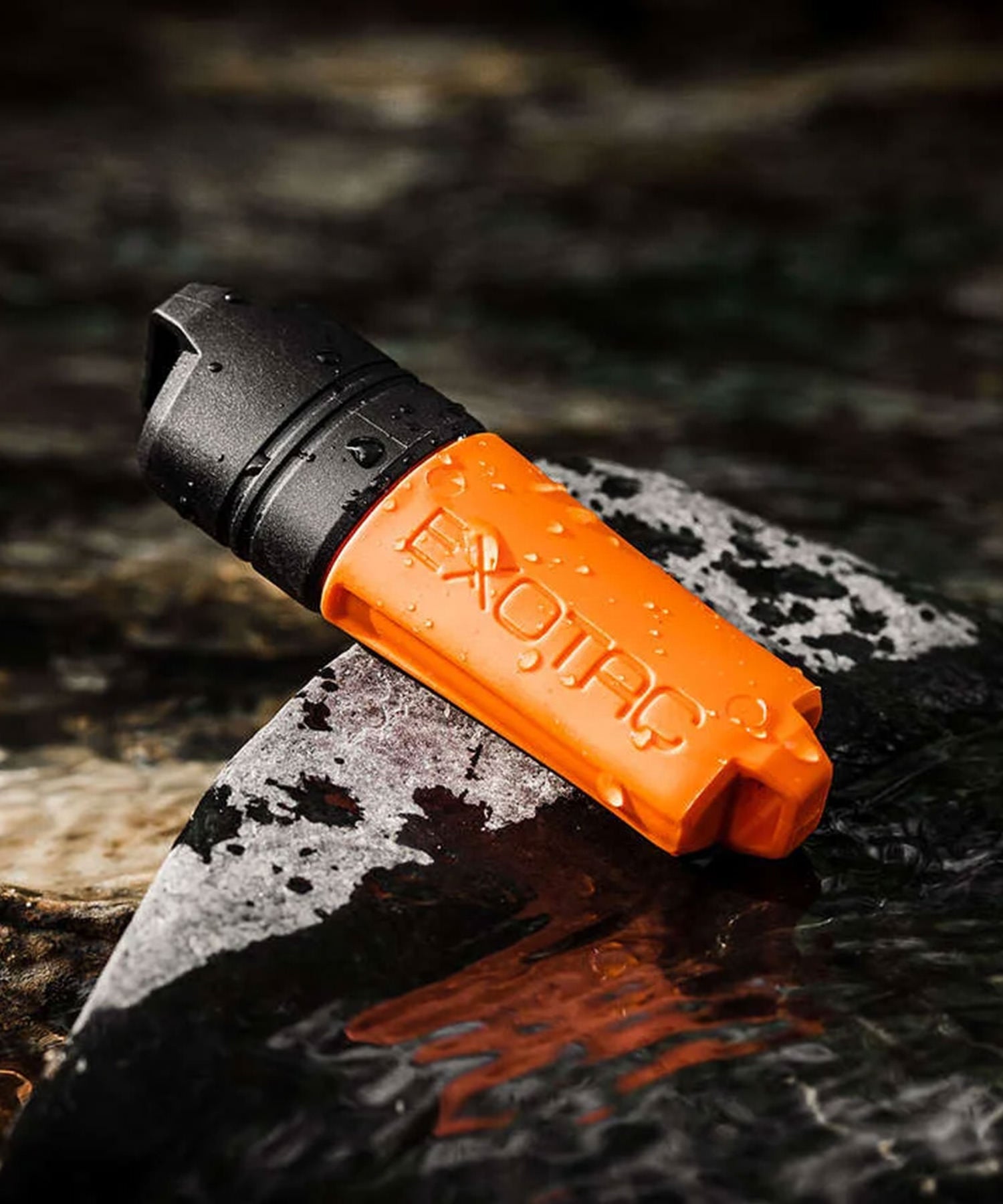exotac firesleeve arancione su roccia del corso d'acqua