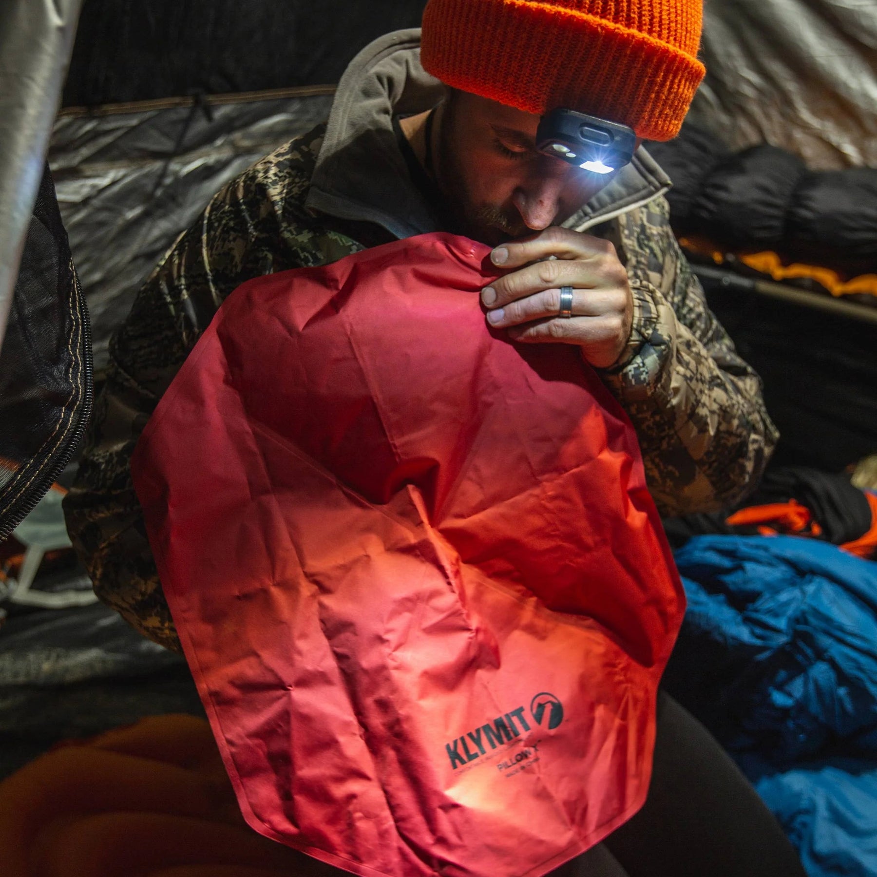 ESCURSIONISTA CHE GONFIA IL SUO CUSCINO KLYMIT PILLOW X ROSSO