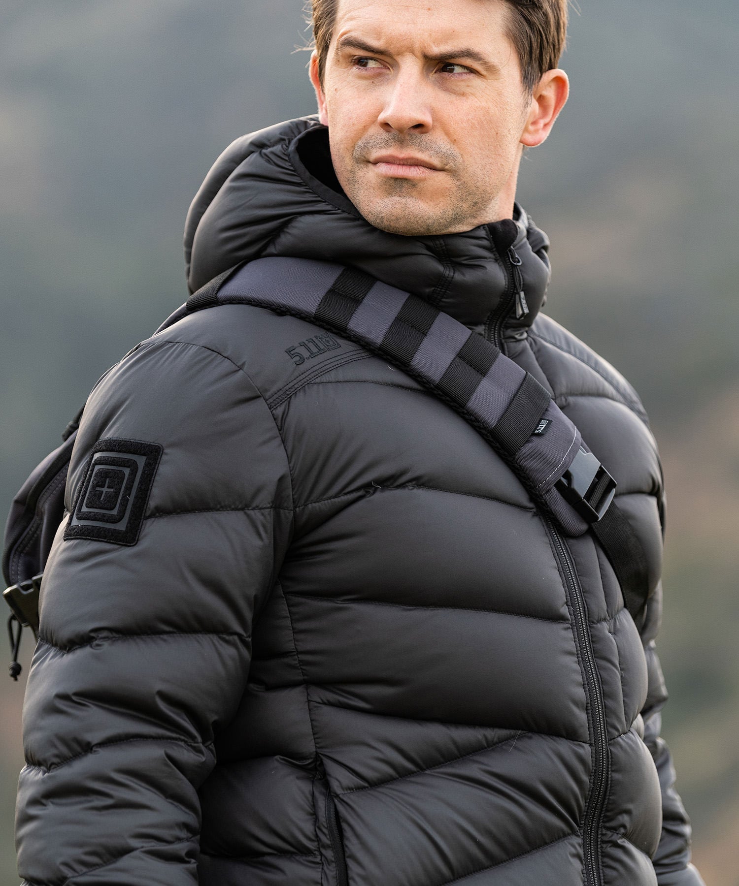 uomo con il suo sling pack coal e il giubbino di 5.11 tactical - vista frontale