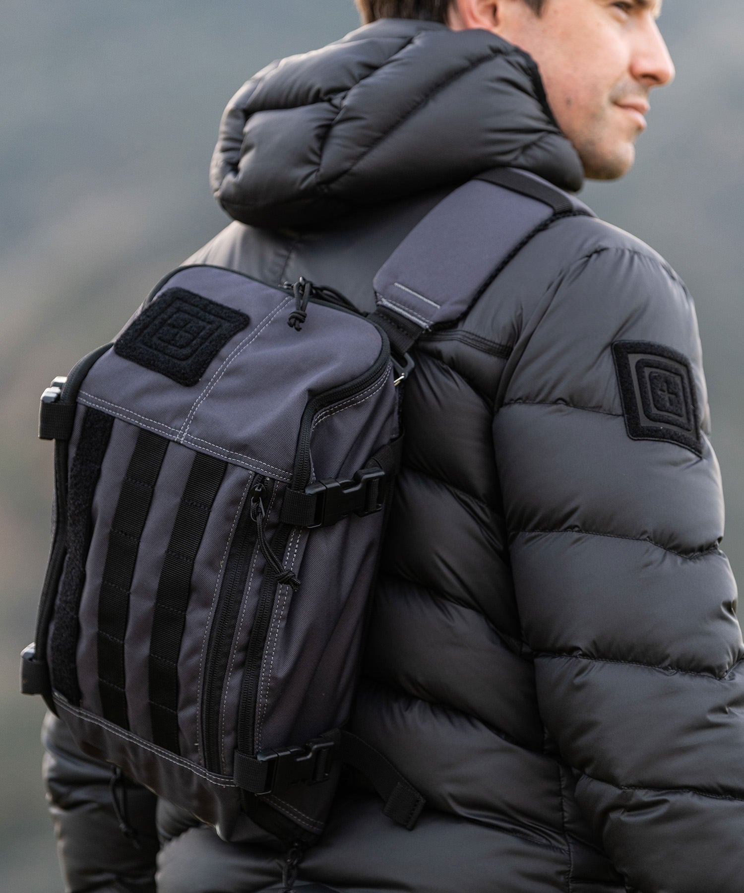 uomo con il suo sling pack coal e il giubbino di 5.11 tactical