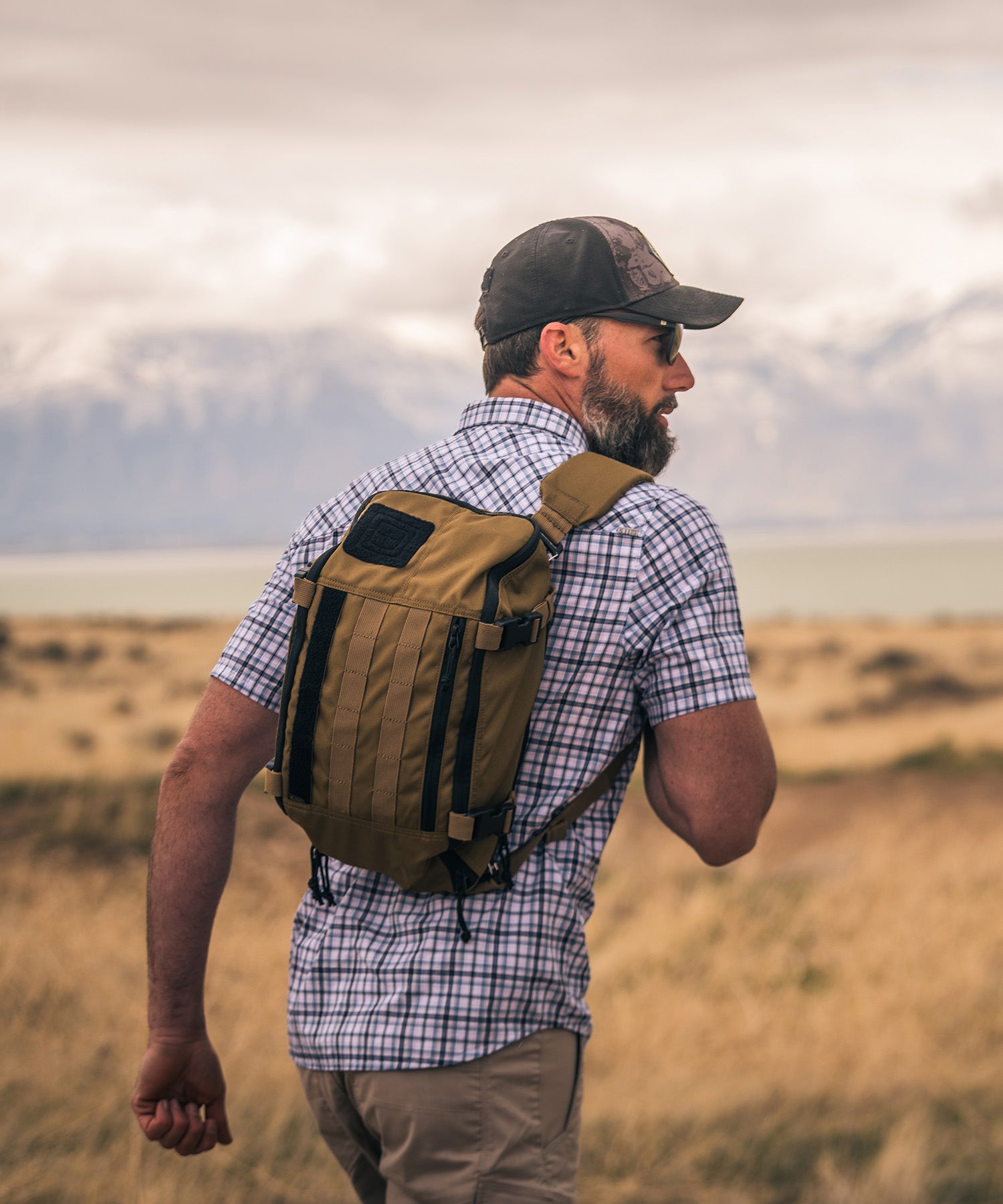 uomo percorre strada di campagna con il suo sling pack kangaroo di 5.11 tactical