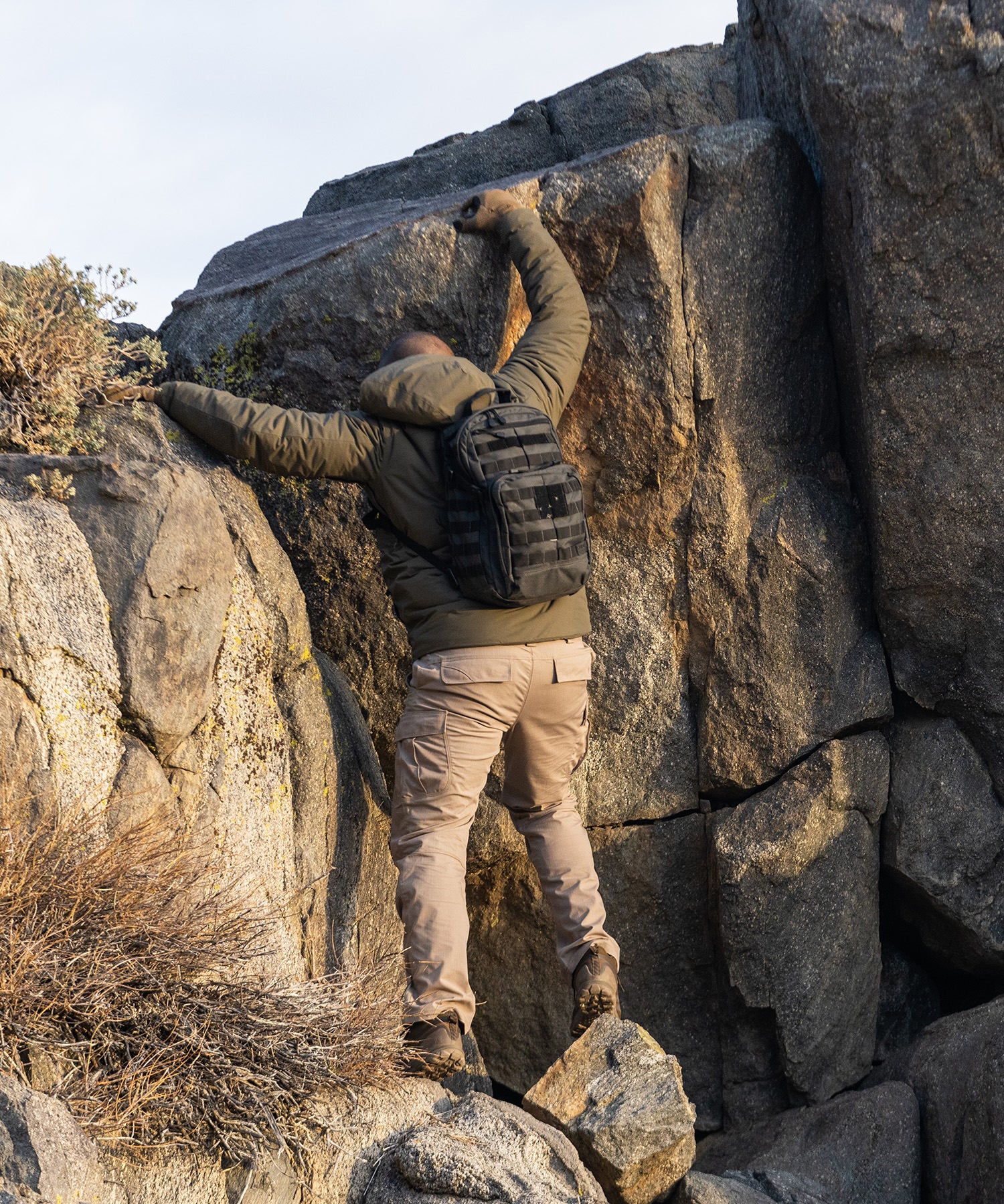 uomo si arrampica con zaino RUSH12 2.0 double tap