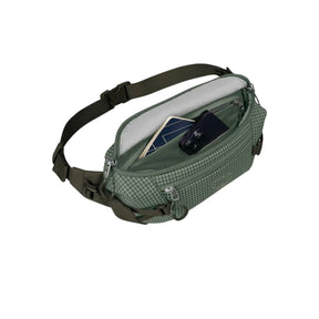 Osprey Transporter Waist Pack marsupio da 3 litri realizzato in tessuto tecnico con trama a griglia e logo frontale, dotato di tasca esterna con zip, cinghie di compressione laterali e cintura regolabile con fibbia a scatto per escursionismo e tempo libero.