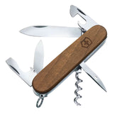 Victorinox Spartan Wood. Coltellino svizzero multiuso con guancette ergonomiche in legno di noce pregiato e logo inciso. Dotato di 10 funzioni essenziali tra cui lama grande, piccola, apriscatole, cacciaviti, spelafili e cavatappi. Strumento tascabile elegante e sostenibile per uso quotidiano.