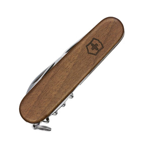 Victorinox Spartan Wood. Coltellino svizzero multiuso con guancette ergonomiche in legno di noce pregiato e logo inciso. Dotato di 10 funzioni essenziali tra cui lama grande, piccola, apriscatole, cacciaviti, spelafili e cavatappi. Strumento tascabile elegante e sostenibile per uso quotidiano.