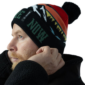 Pentagon Sanctuary Knit Beanie. Berretto invernale in morbido filato acrilico con pon pon e grafica naturale. Design a maglia traspirante con scritta su risvolto a costine per vestibilità comoda. Accessorio termico per protezione dal freddo in attività outdoor.
