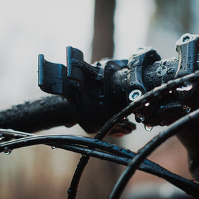 Armytek Bicycle Mount ABM-01. Supporto per bicicletta progettato per il fissaggio sicuro di torce con diametro del corpo di 24.5 mm. Costruito in materiale plastico robusto, presenta un morsetto da manubrio con interno dentellato e manopola di serraggio a vite per garantire massima stabilità. Il sistema di ritenzione superiore blocca la torcia in posizione tramite un anello elastico resistente, rendendolo ideale per l'illuminazione durante le uscite in bici.