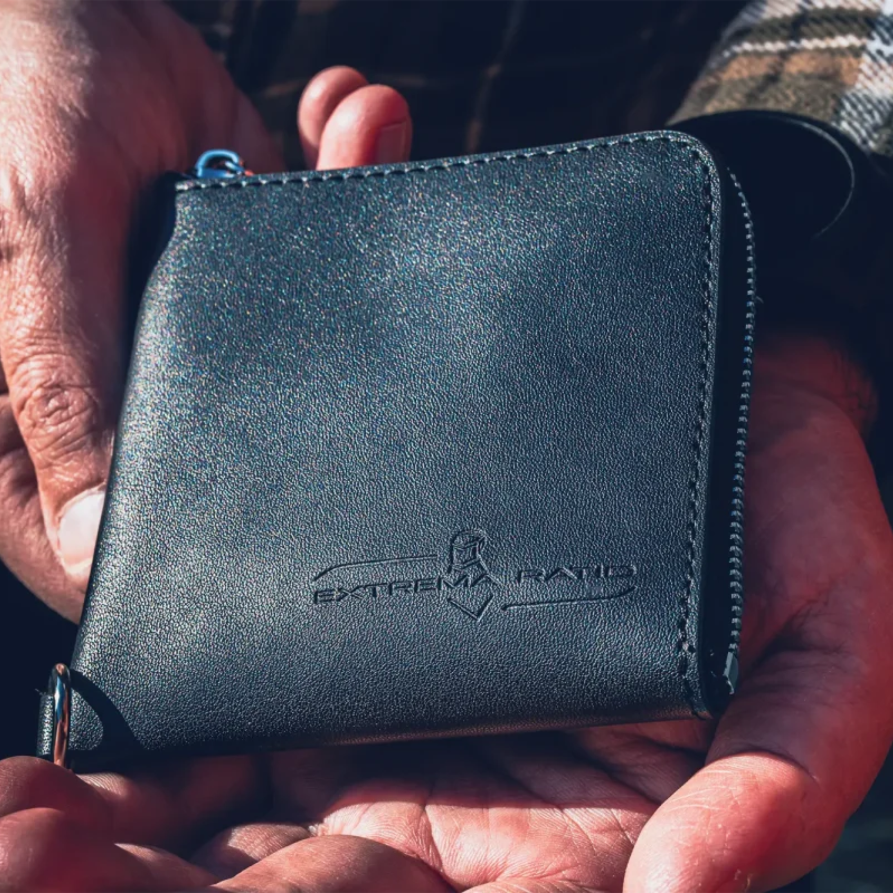 Extrema Ratio The Carry Zip Leather Wallet: Portafoglio compatto realizzato in pelle di alta qualità con chiusura a zip perimetrale. Caratterizzato dal logo Extrema Ratio impresso a caldo e dotato di anello a D esterno per l'aggancio di cordini o catene. Design robusto ed elegante per l'organizzazione sicura di contanti e carte.