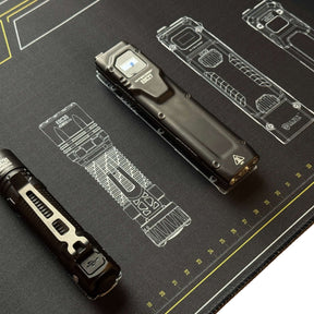 Nitecore Tappetino Mouse XL. Sottomano tecnico da scrivania con schemi grafici di torce serie EDC e righelli graduati sui bordi. Superficie ampia in tessuto morbido per manutenzione o gaming con loghi tecnologia Lumin Shield.