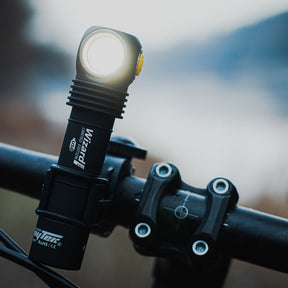 Armytek Bicycle Mount ABM-01. Supporto per bicicletta progettato per il fissaggio sicuro di torce con diametro del corpo di 24.5 mm. Costruito in materiale plastico robusto, presenta un morsetto da manubrio con interno dentellato e manopola di serraggio a vite per garantire massima stabilità. Il sistema di ritenzione superiore blocca la torcia in posizione tramite un anello elastico resistente, rendendolo ideale per l'illuminazione durante le uscite in bici.