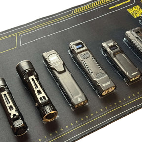 Nitecore Tappetino Mouse XL. Sottomano tecnico da scrivania con schemi grafici di torce serie EDC e righelli graduati sui bordi. Superficie ampia in tessuto morbido per manutenzione o gaming con loghi tecnologia Lumin Shield.