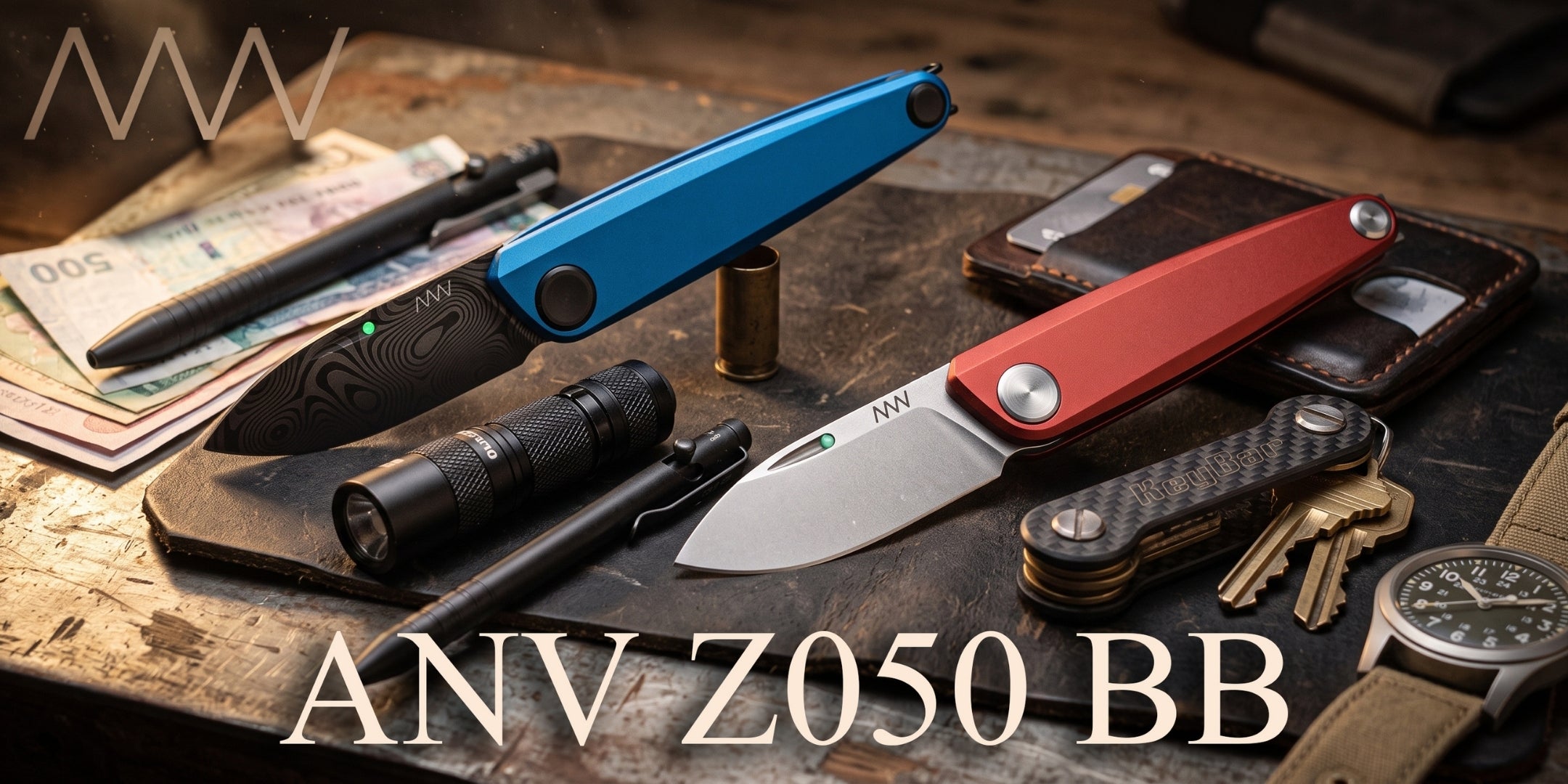 ANV Z050 BB coltello pieghevole compatto con lama liscia e punto luminescente sul dorso, fotografato insieme ad attrezzatura EDC come torcia, penna e portachiavi su piano da lavoro.