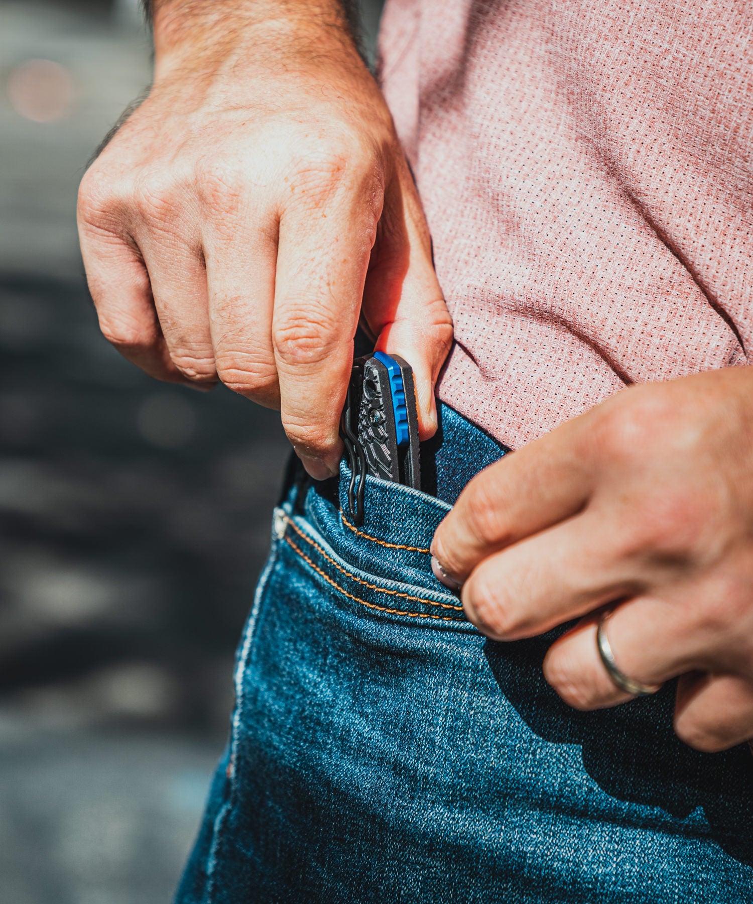 Paolo di backpacco estrae dalla tasca dei jeans 5.11 il fox baby core nero con distanziale in alluminio anodizzato blu