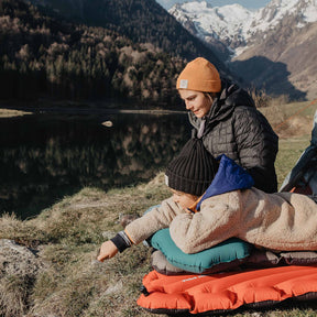 CUSCINO KLYMIT PILLOW XL AZZURO CON RAGAZZA CHE CI DORME SOPRA