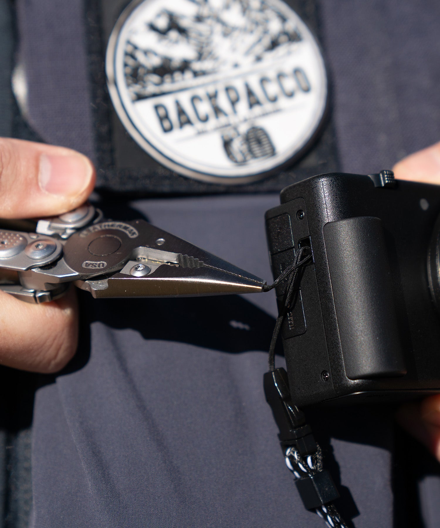 Paolo di backpacco estrae il cordino della macchina fotografica con il leatherman free p2