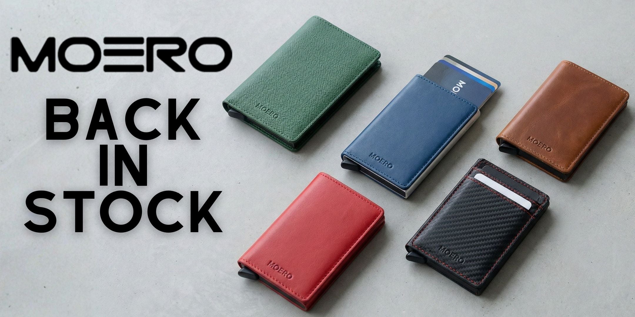 Moero Portafoglio Smart Slim collezione assortita con meccanismo pop-up per carte di credito e protezione RFID. Banner promozionale Back In Stock con logo Moero in primo piano su sfondo minimalista grigio.