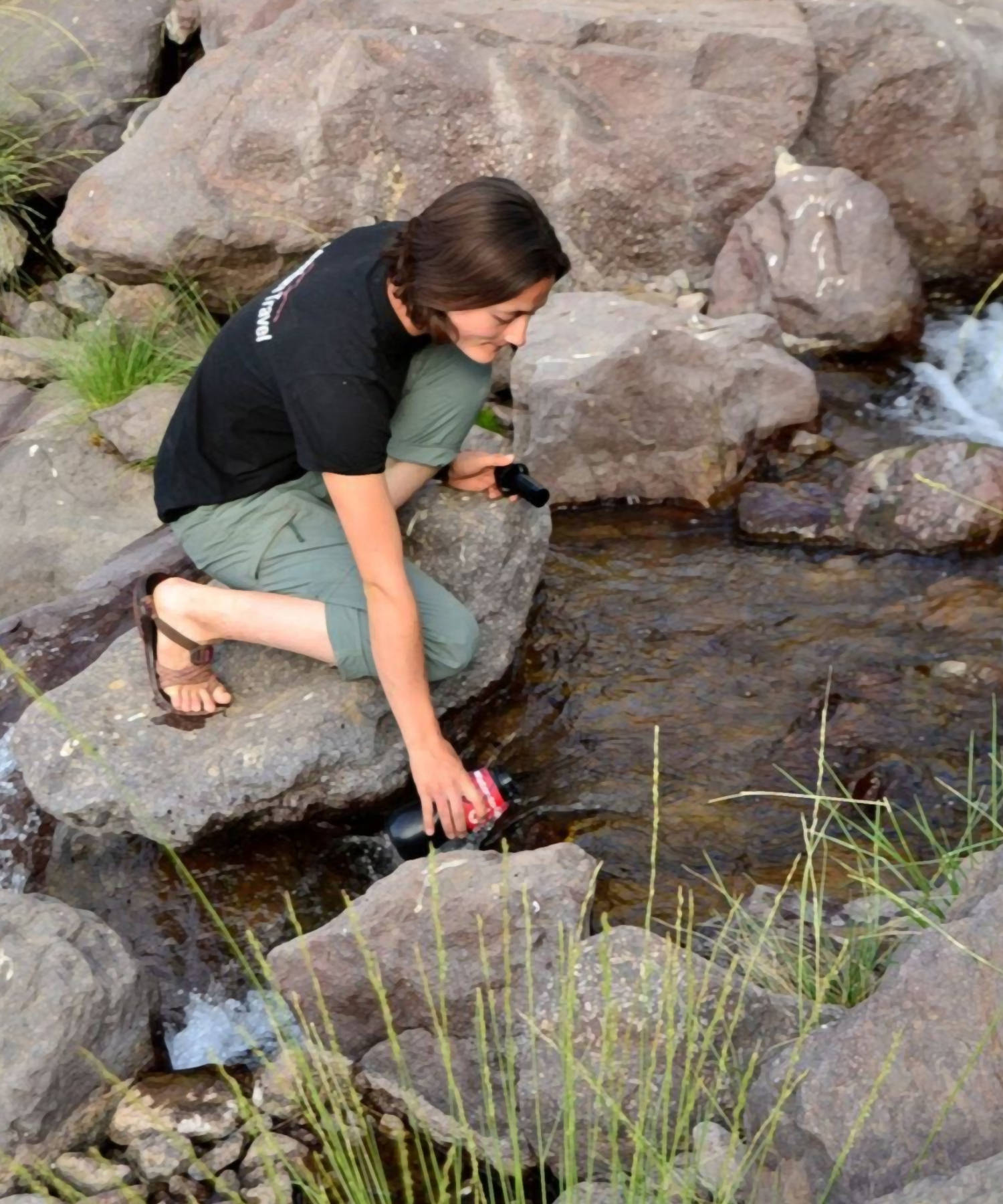 donna prende acqua dal torrente con la water to go classic durante un camping