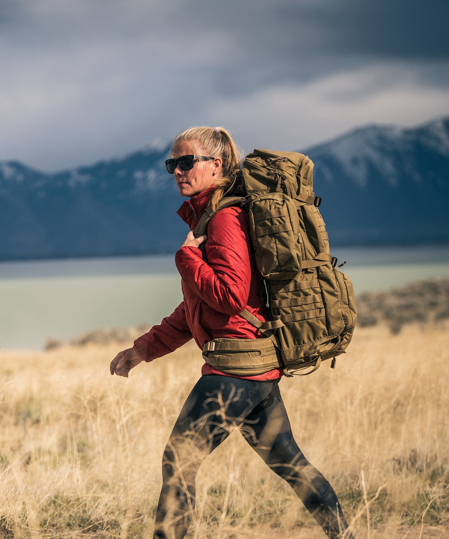 donna fa hiking con zaino rush100 in giornata ventosa