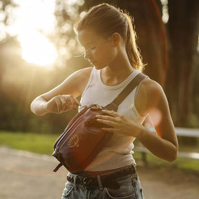 Osprey Transporter Waist Pack marsupio da 3 litri realizzato in tessuto tecnico con trama a griglia e logo frontale, dotato di tasca esterna con zip, cinghie di compressione laterali e cintura regolabile con fibbia a scatto per escursionismo e tempo libero.