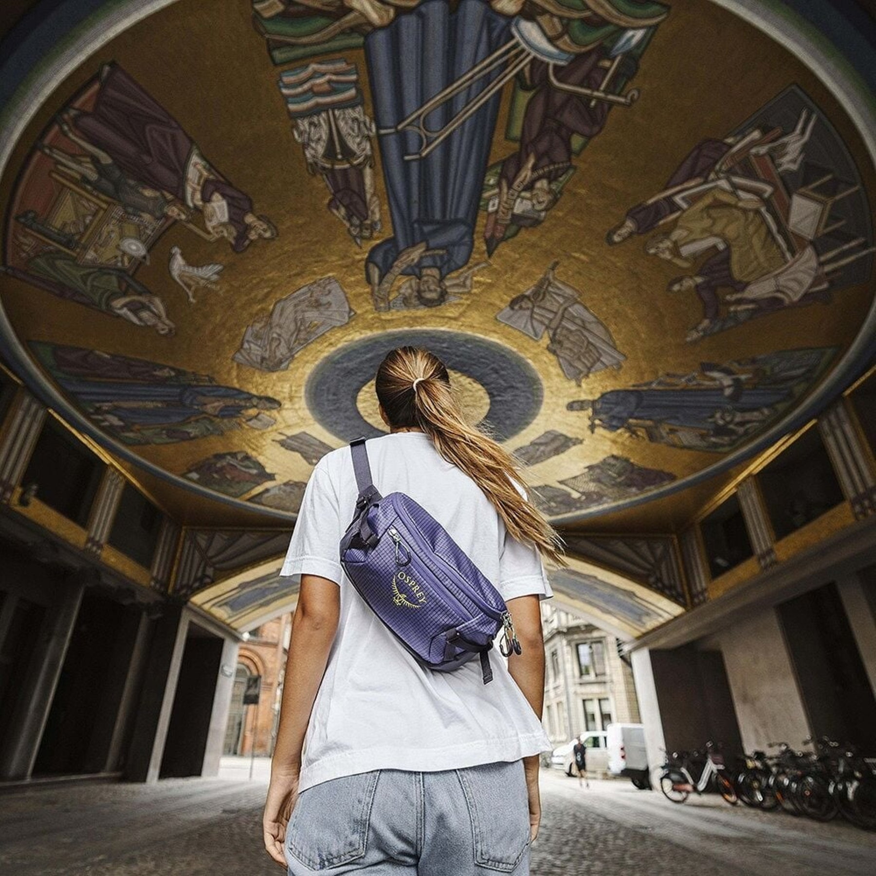 Osprey Transporter Waist Pack marsupio da 3 litri realizzato in tessuto tecnico con trama a griglia e logo frontale, dotato di tasca esterna con zip, cinghie di compressione laterali e cintura regolabile con fibbia a scatto per escursionismo e tempo libero.